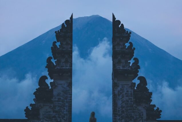 woman in between on concrete landmarks near white clouds