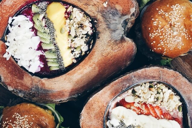 flat-lay of hamburger, fruit salad, and strawberry shake